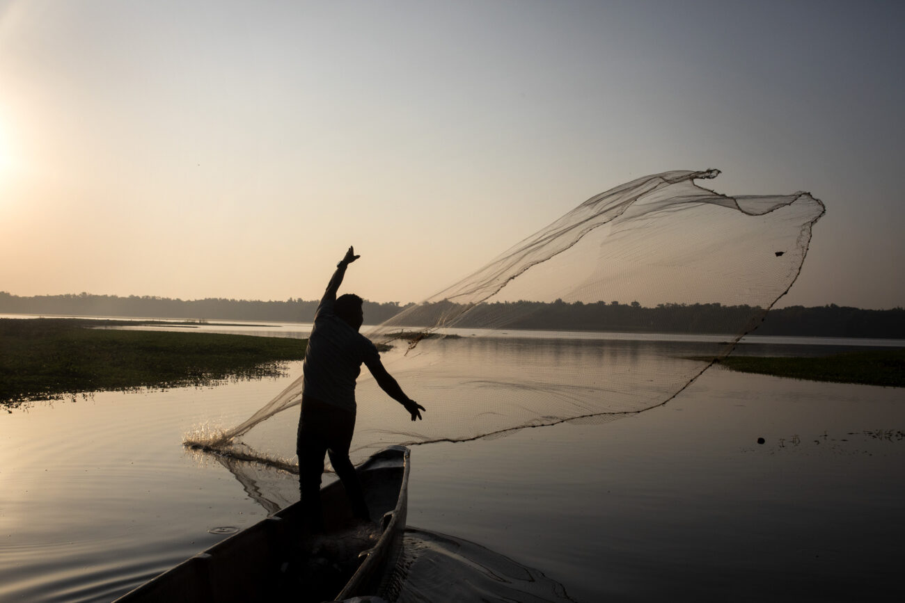En pleno amanecer, Juanca arroja una atarraya en la entrada de la ciénaga Alfandoque. El resultado de la pesca consiste en una treintena de alevinos que rápidamente son devueltos al agua. Foto: Pau Coll / Ruido Photo