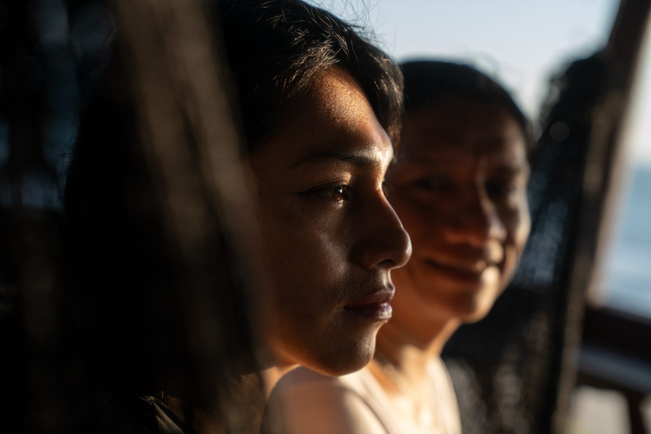 Eliss sonríe mirando a Taylor, una enchaquirado que representa la fuerza y el legado de una generación más joven. Mientras que las generaciones anteriores debían esconderse y dividir sus identidades para vivir como enchaquirados, hoy las más jóvenes pueden vivir plenamente como mujeres, hormonadas y sin necesidad de ocultar quiénes son.. Foto: Irina Dambrauskas