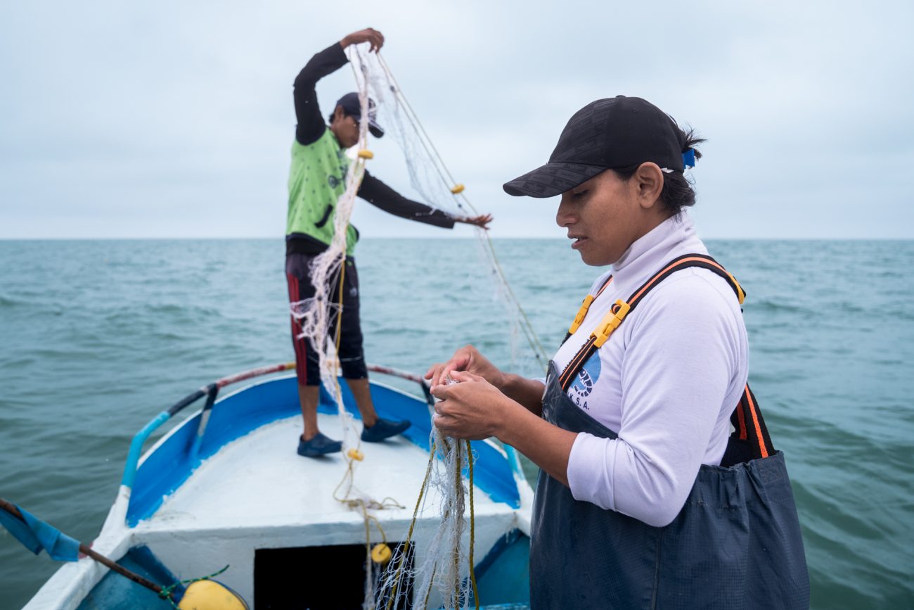 Mientras Jordy recoge la red del agua, Taylor se ocupa de quitar la pesca atrapada entre sus mallas. Foto: Irina Dambrauskas